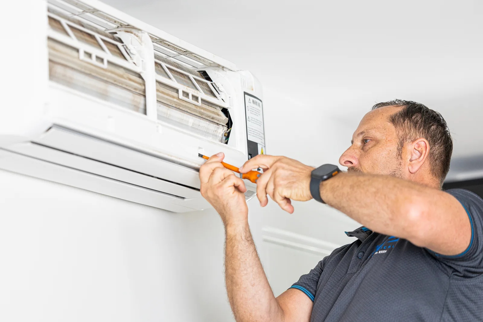 Technician servicing a wall-mounted split system unit